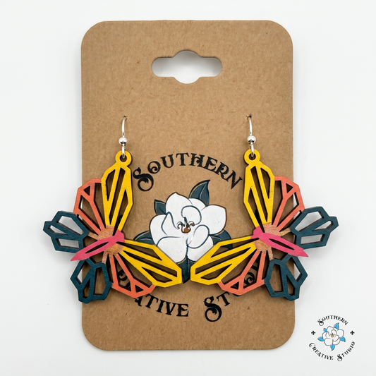 Yellow and coral geometric butterfly wood earrings on Southern Creative Studio hang card