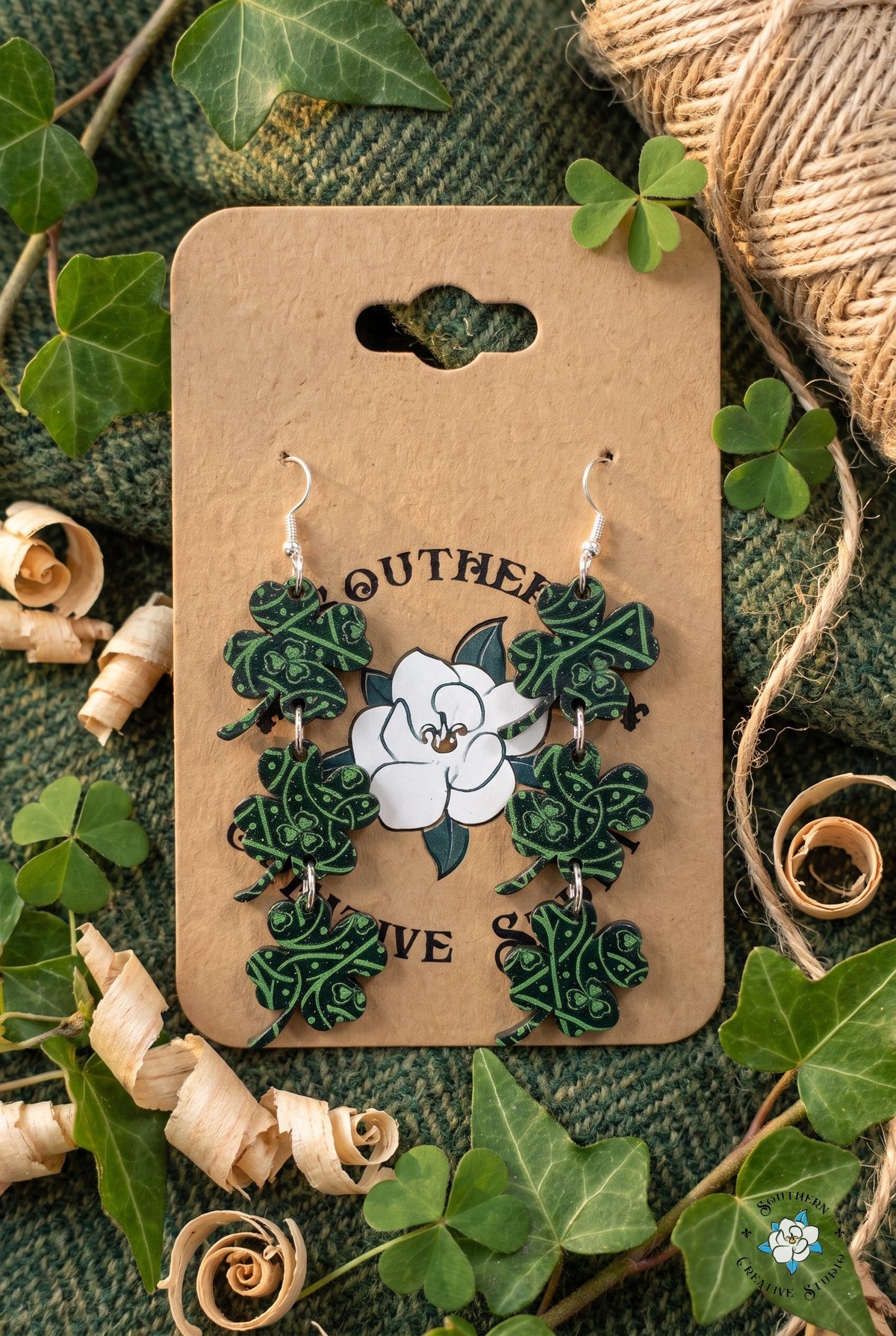 Celtic knot clover dangle earrings on card in a tweed and ivy flat lay