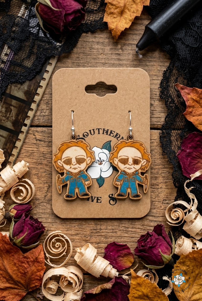 Horror slasher wood earrings flat lay with black lace, dried roses and film strip