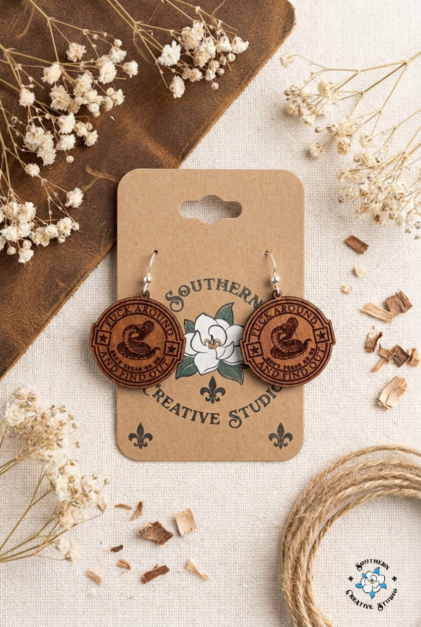 Flat lay moodboard of FAAFO snake medallion hand-painted wood earrings on Southern Creative Studio card
