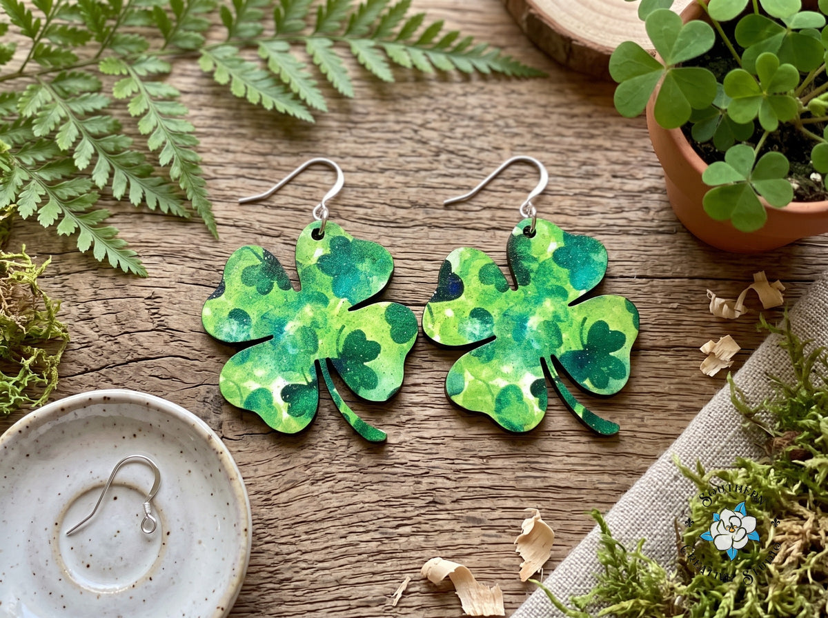 Marbled four leaf clover earrings styled with ferns, moss and shamrocks