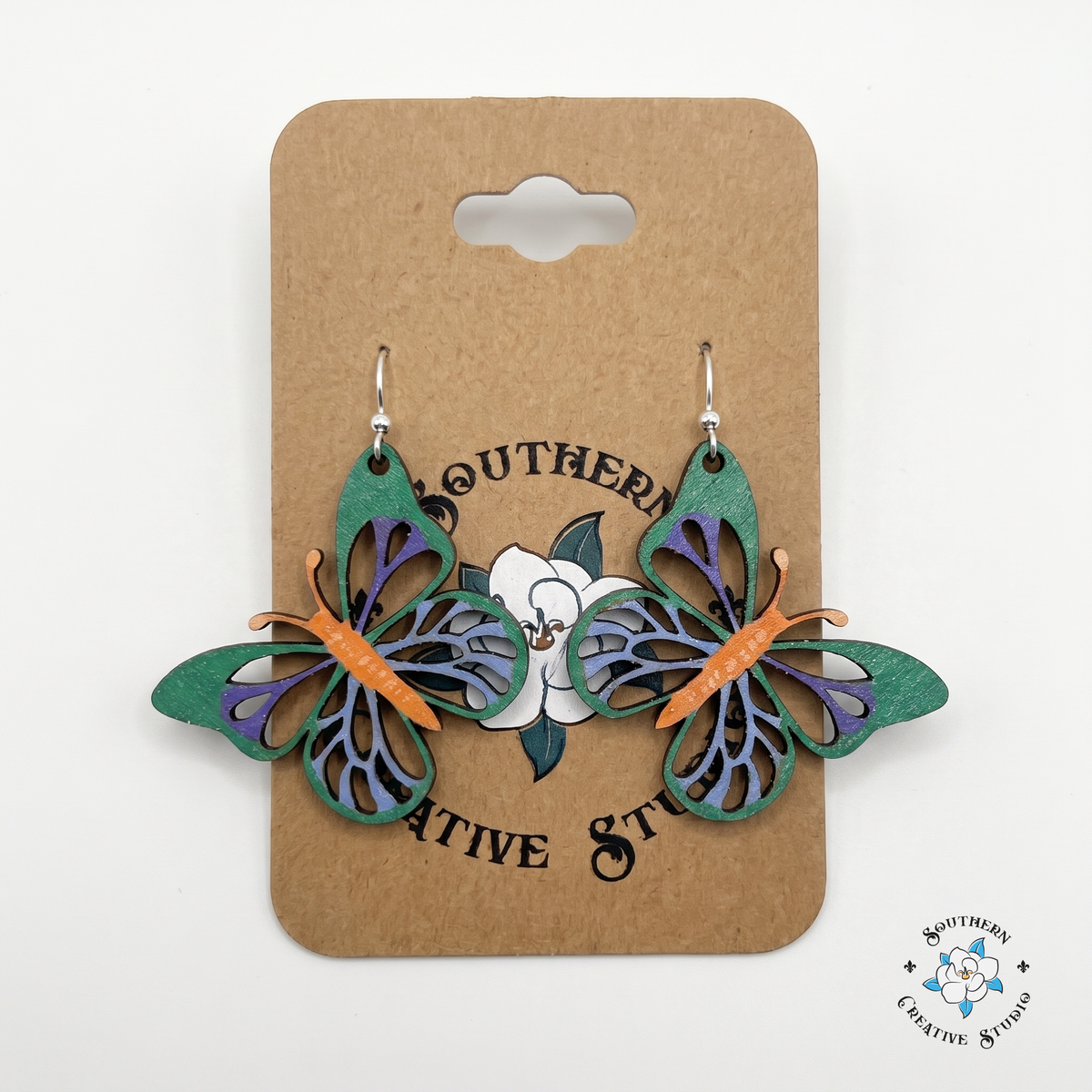 Green and purple butterfly wood earrings on Southern Creative Studio hang card