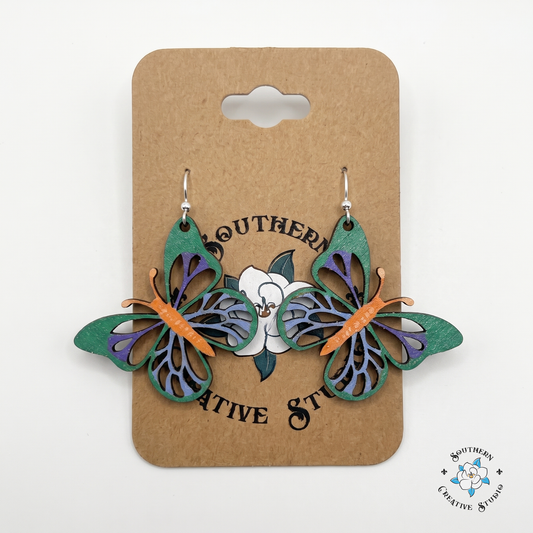 Green and purple butterfly wood earrings on Southern Creative Studio hang card