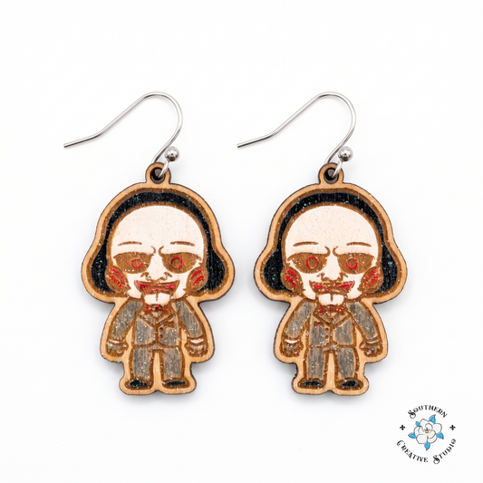 Creepy puppet hand-painted wood dangle earrings with red spiral cheeks and red bow tie on white background