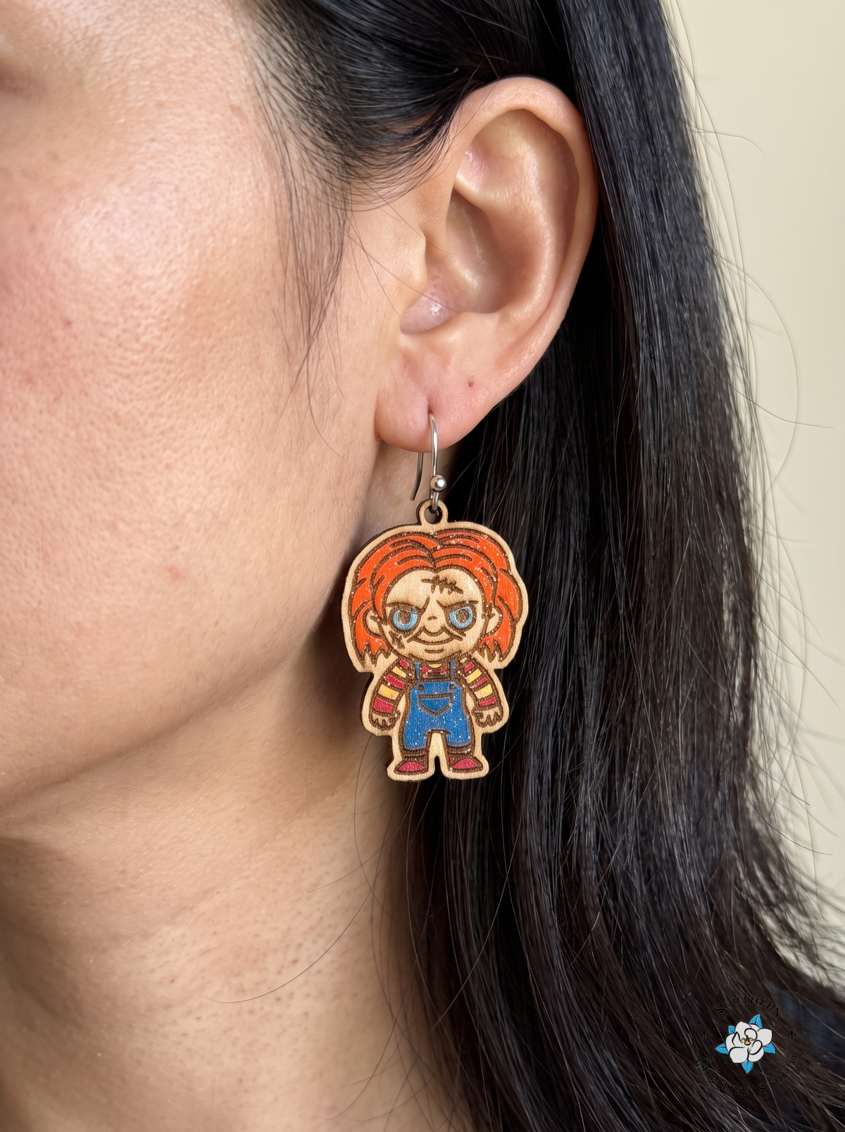 Close-up of woman wearing hand-painted wood killer doll earring