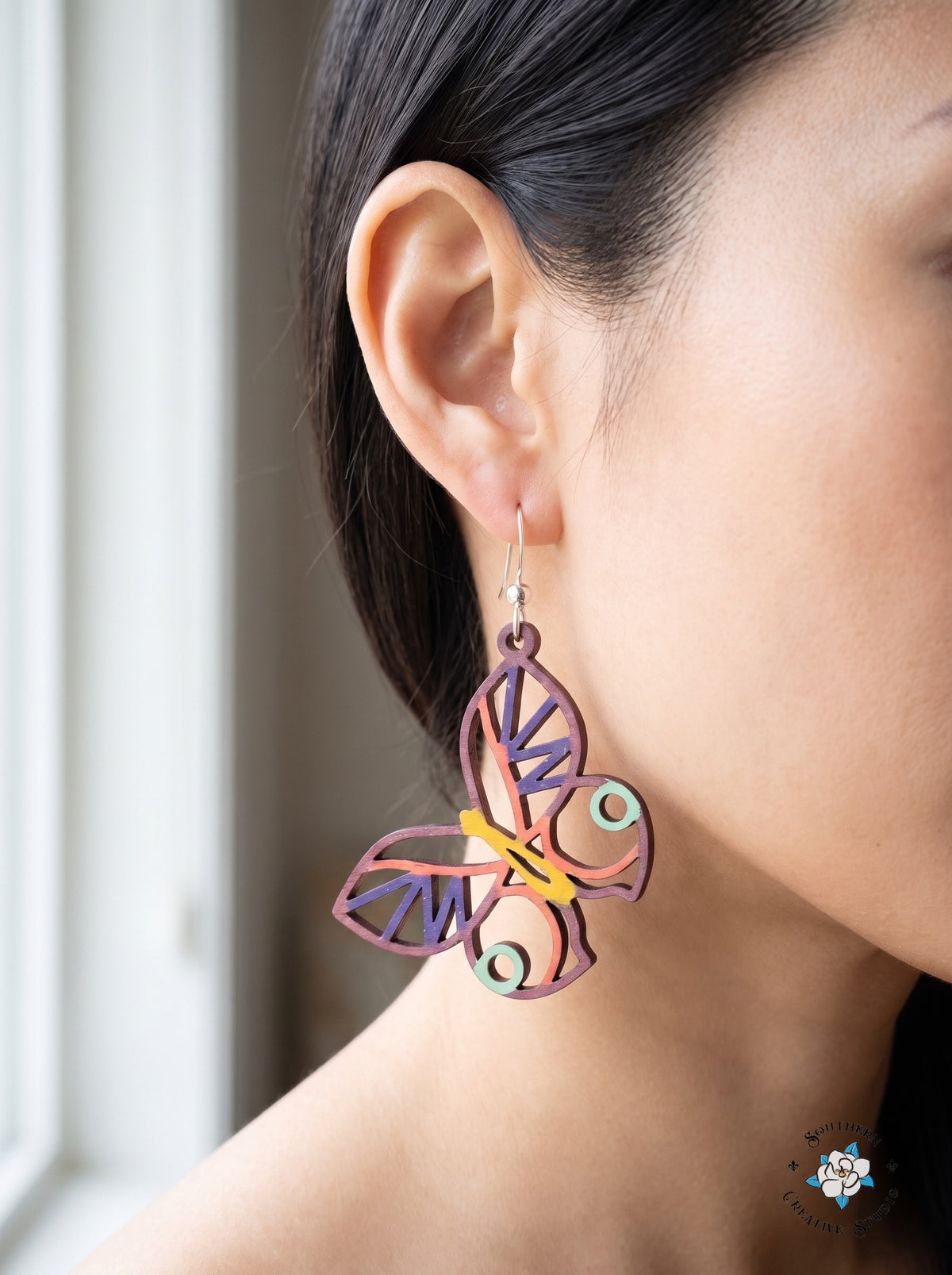 Close-up of woman wearing mint circle butterfly wood dangle earring