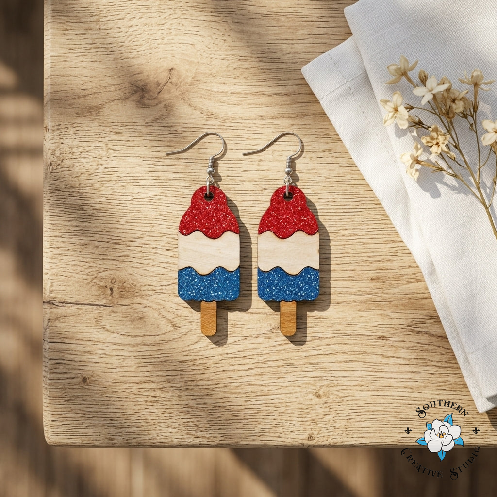 Bomb Pop Popsicle Earrings styled flat lay on wood – patriotic summer jewelry