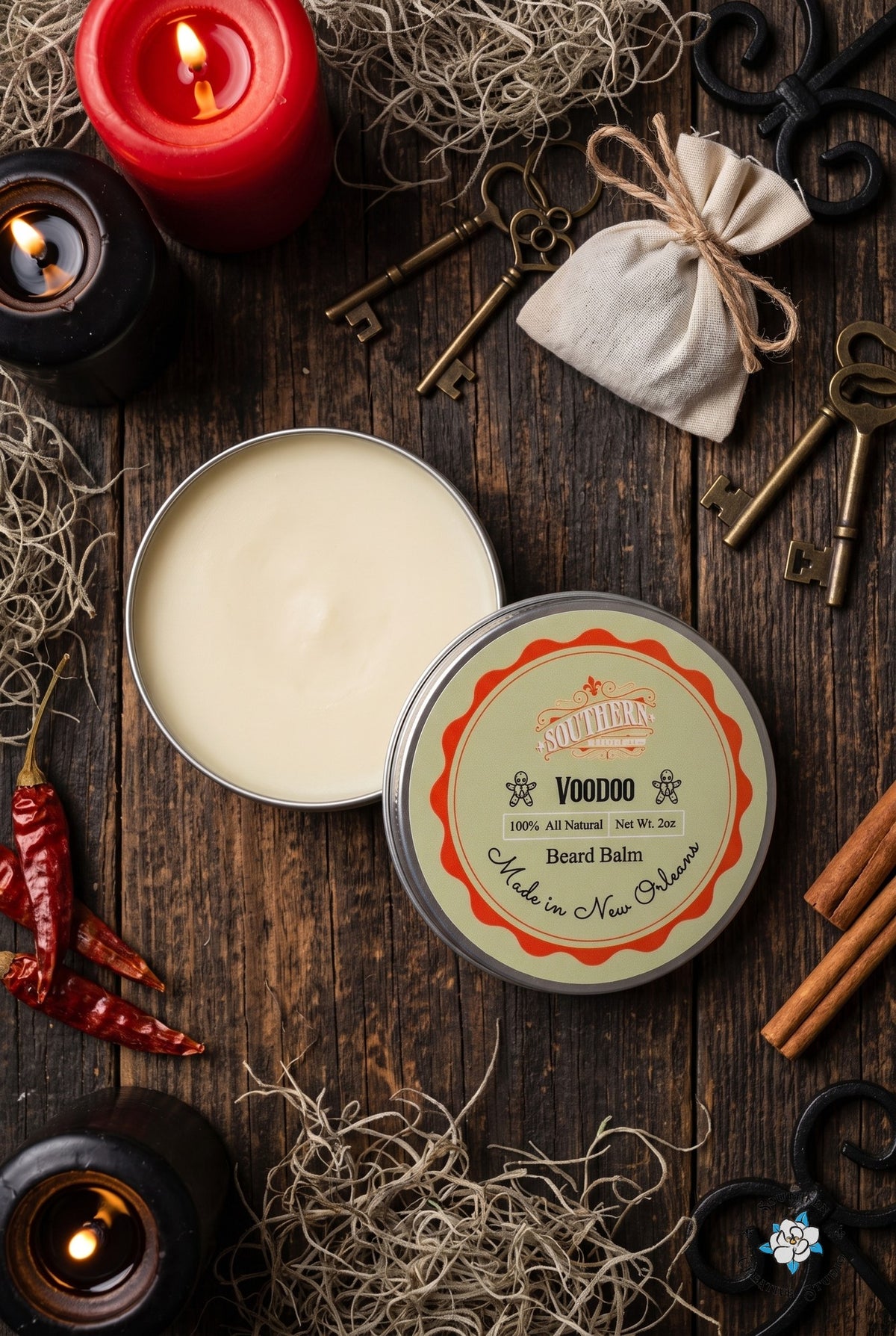 Voodoo beard balm flat lay, open tin and lid with a candle-lit French Quarter apothecary with skeleton keys and Spanish moss