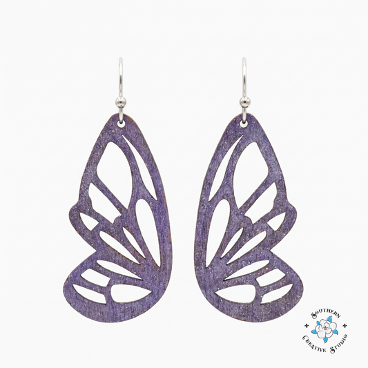 Purple butterfly wing cutout wood earrings on white background