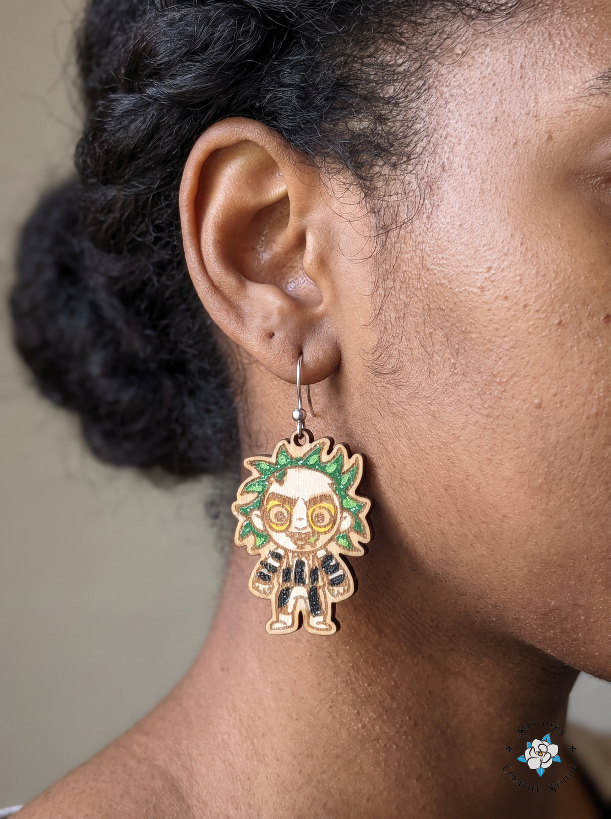 Close-up of woman wearing hand-painted wood striped suit ghoul earring