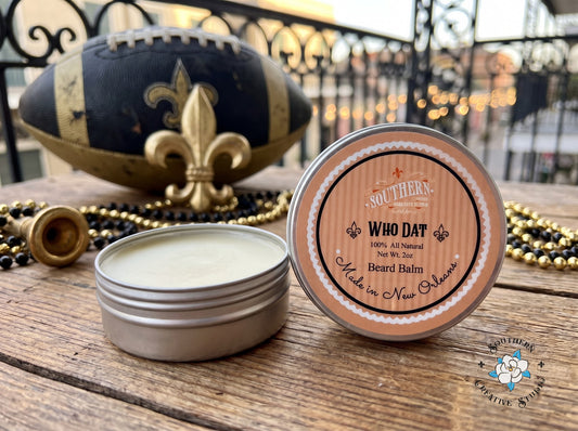 WhoDat beard balm by Southern Creative Studio, open tin and lid with black and gold Saints game-day with a fleur-de-lis and beads