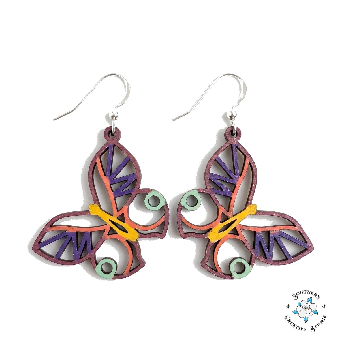Mint circle butterfly earrings, open see-through layered hand-painted wood with plum edge, coral and purple accents on white background