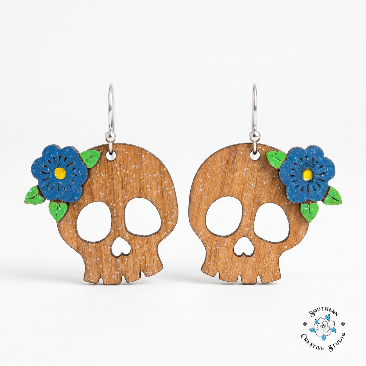 Flower skull earrings hand-painted wood with layered blue flower on white background