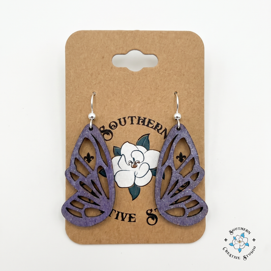 Hand-painted purple butterfly wing wood earrings on Southern Creative Studio kraft hang card