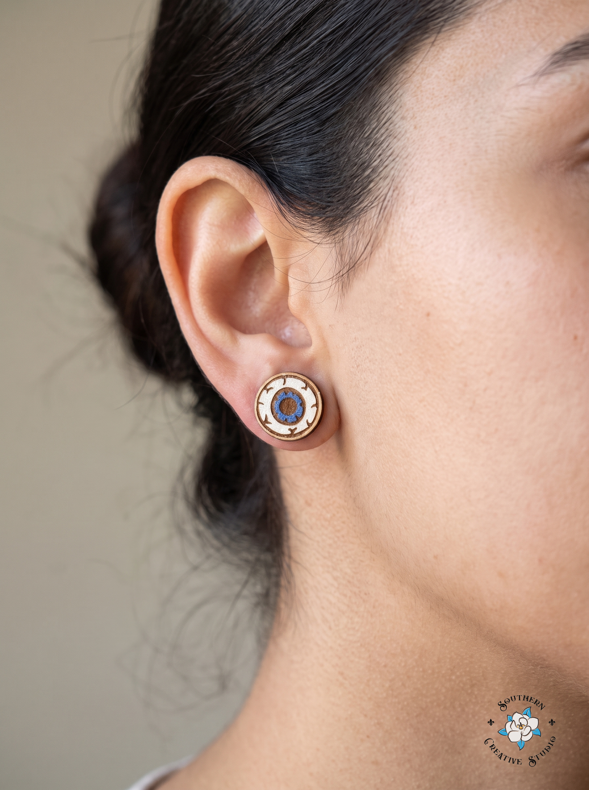 Woman wearing wood eyeball stud earring close-up