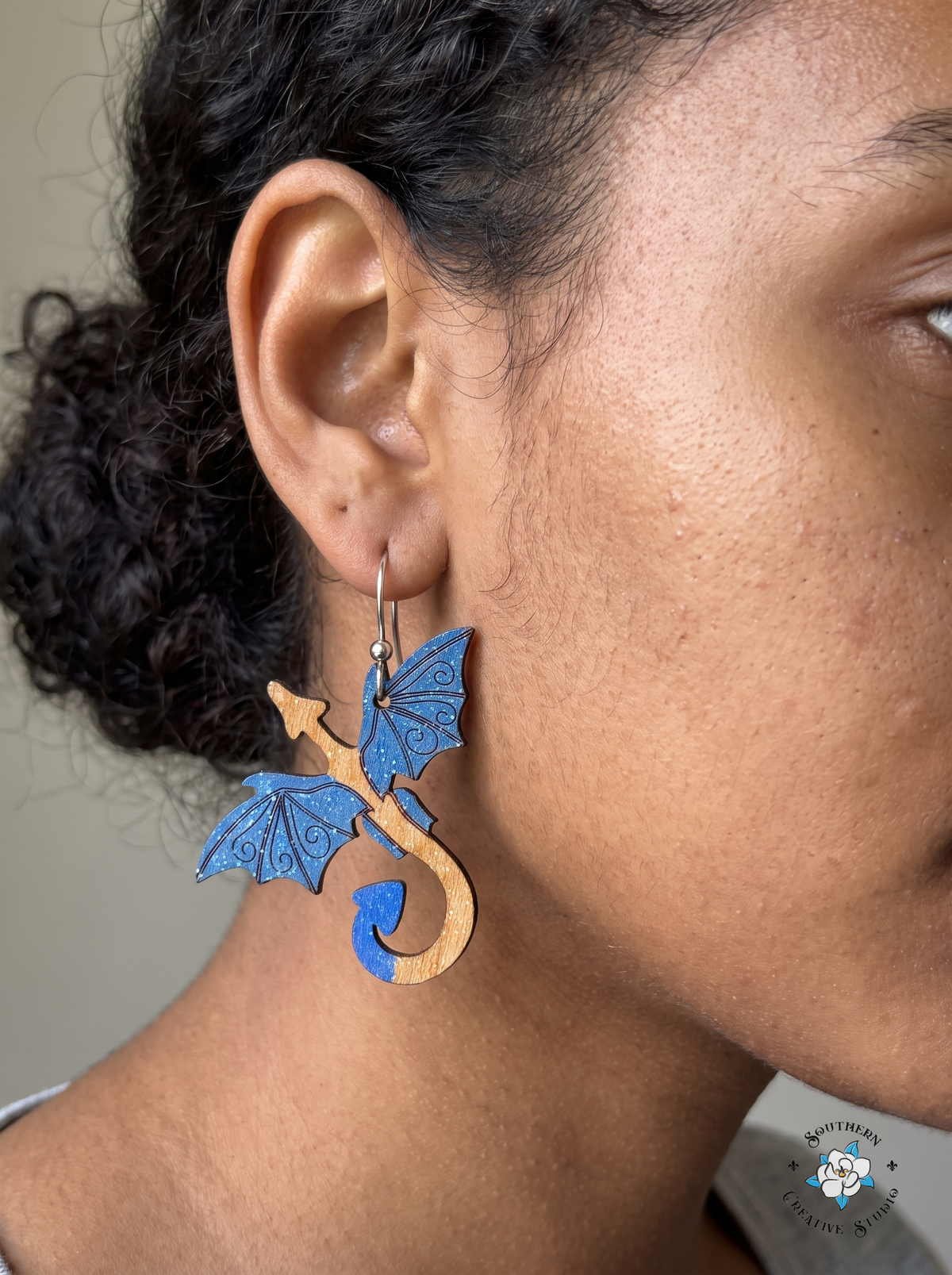 Woman wearing hand-painted wood blue dragon fantasy dangle earring
