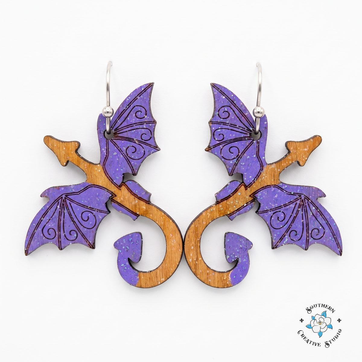 Purple dragon hand-painted wood dangle earrings with violet wings on white background