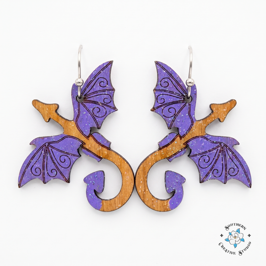 Purple dragon hand-painted wood dangle earrings with violet wings on white background
