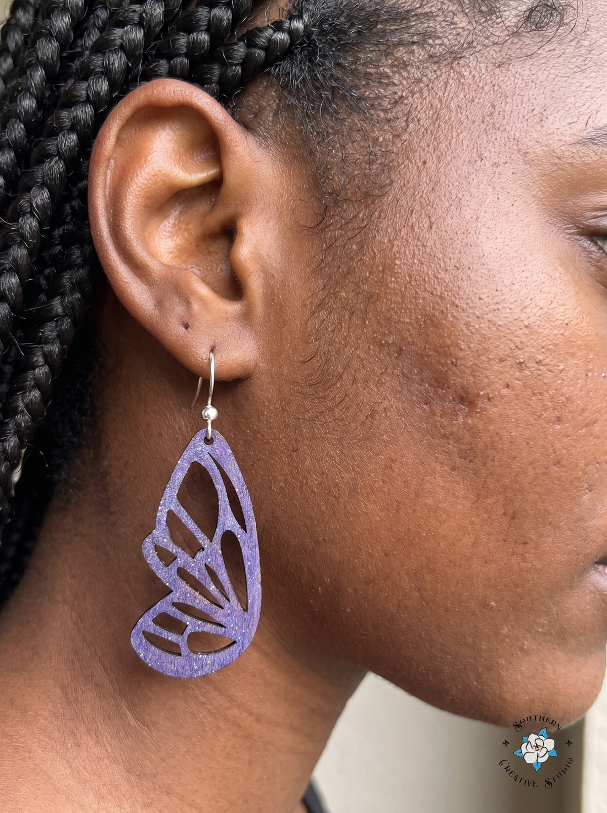 Woman wearing hand-painted wood purple butterfly wing cutout dangle earring