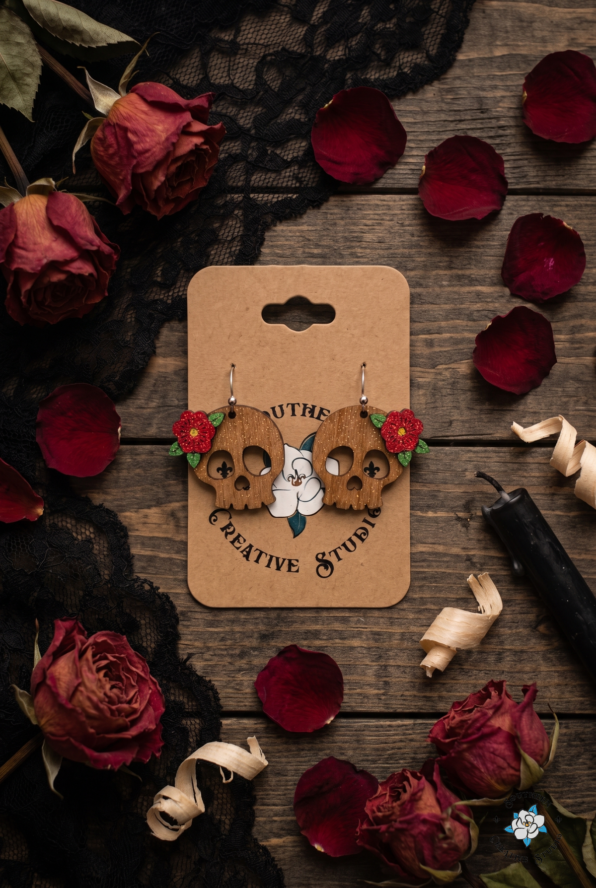 Gothic red rose skull earrings flat lay with black lace, dried roses and rose petals