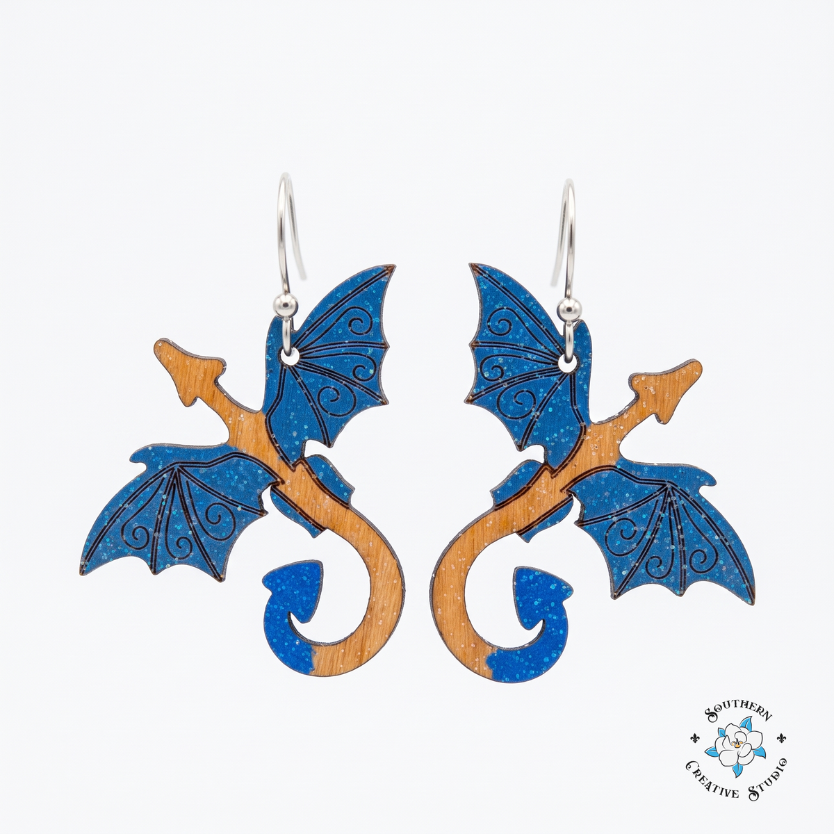 Blue dragon hand-painted wood dangle earrings with sapphire wings on white background