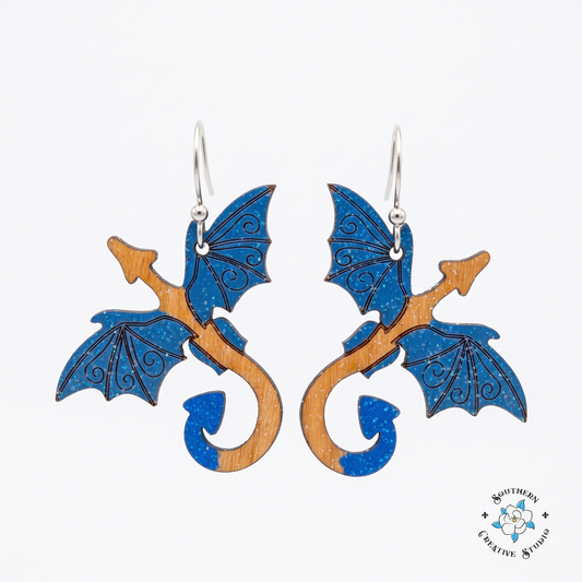 Blue dragon hand-painted wood dangle earrings with sapphire wings on white background