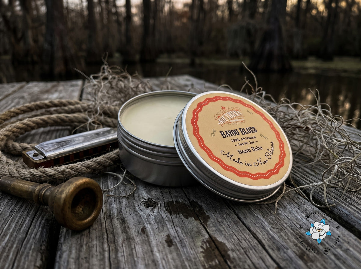 Bayou Blues beard balm close-up, open tin with leaning lid and a Louisiana bayou dock with fishing tackle, rope, harmonica and a trumpet mouthpiece