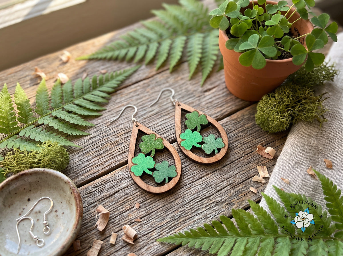 Three clover teardrop earrings styled with ferns, moss and shamrocks