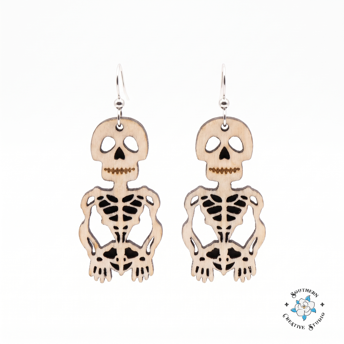 Hand-painted wood skeleton dangle earrings on white background