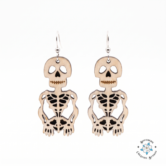 Hand-painted wood skeleton dangle earrings on white background