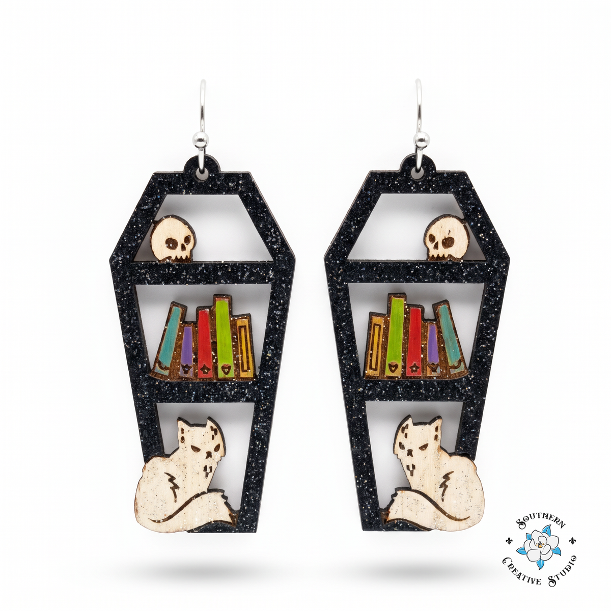Coffin bookshelf earrings hand-painted wood black with skull, books and cat on white background