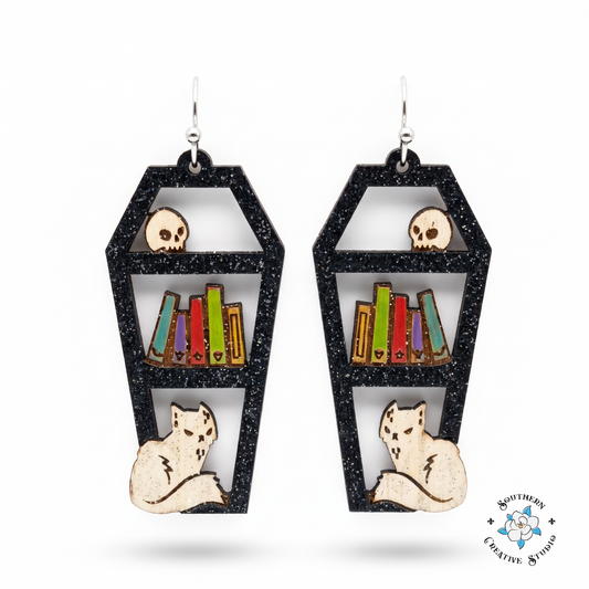Coffin bookshelf earrings hand-painted wood black with skull, books and cat on white background