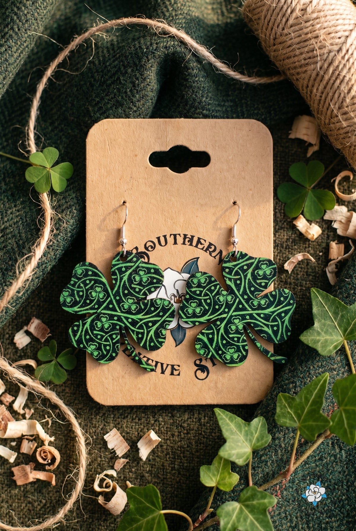 Celtic knot clover earrings on card in a tweed and ivy flat lay