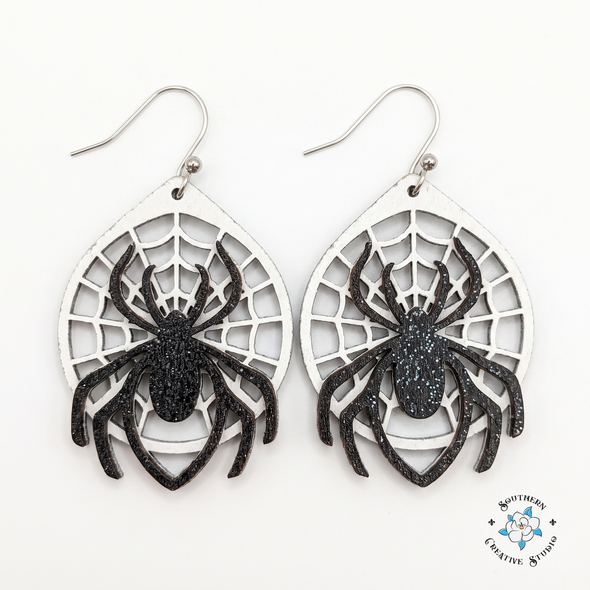 Layered wood spider web dangle earrings, hand-painted, on white background