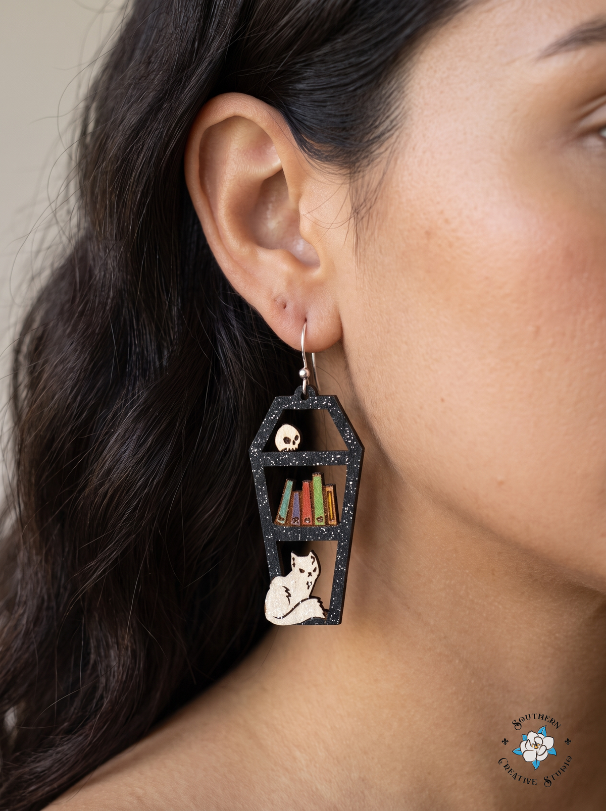Woman wearing coffin bookshelf dangle earring with silver hook close-up