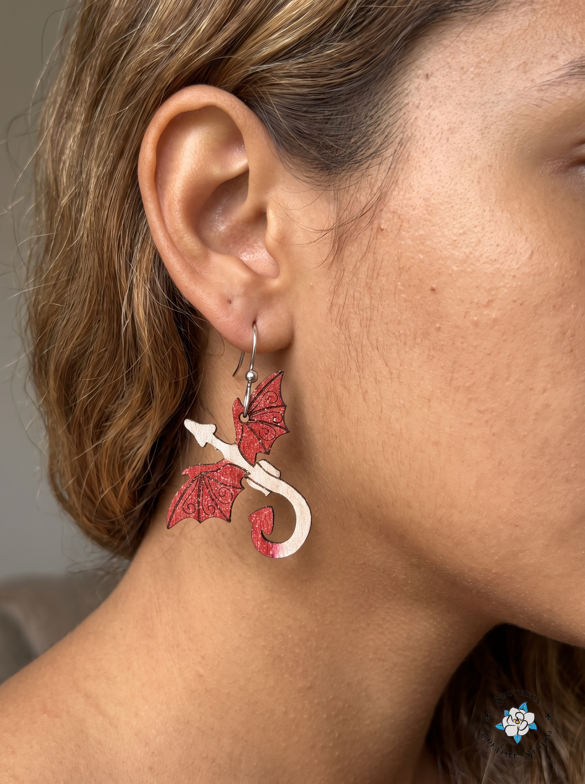 Woman wearing hand-painted wood red dragon fantasy dangle earring