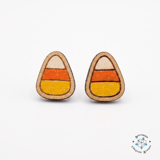 Hand-painted wood candy corn stud earrings on white background