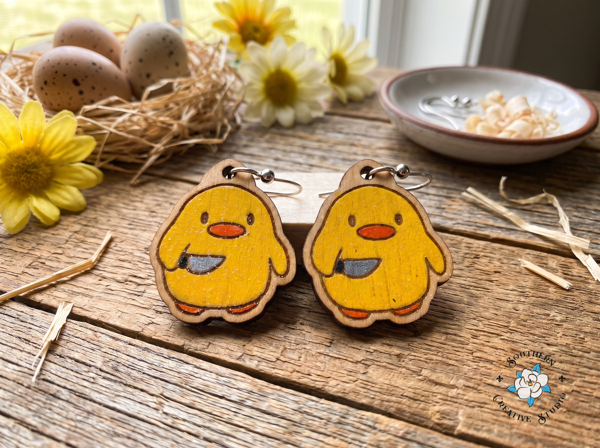 Duck with knife wood earrings on rustic table with speckled eggs, straw nest and daisies