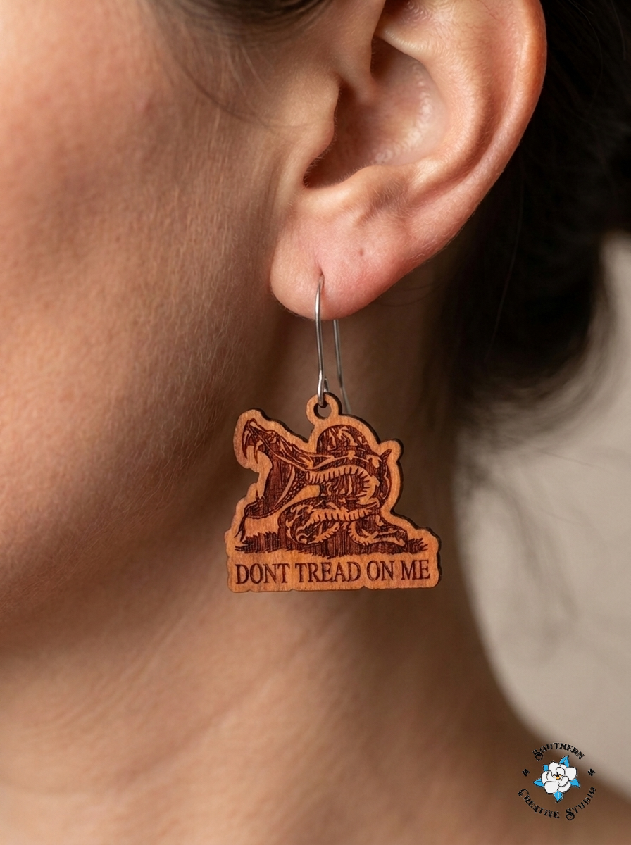Close up of Don't Tread On Me snake hand-painted wood earring on ear