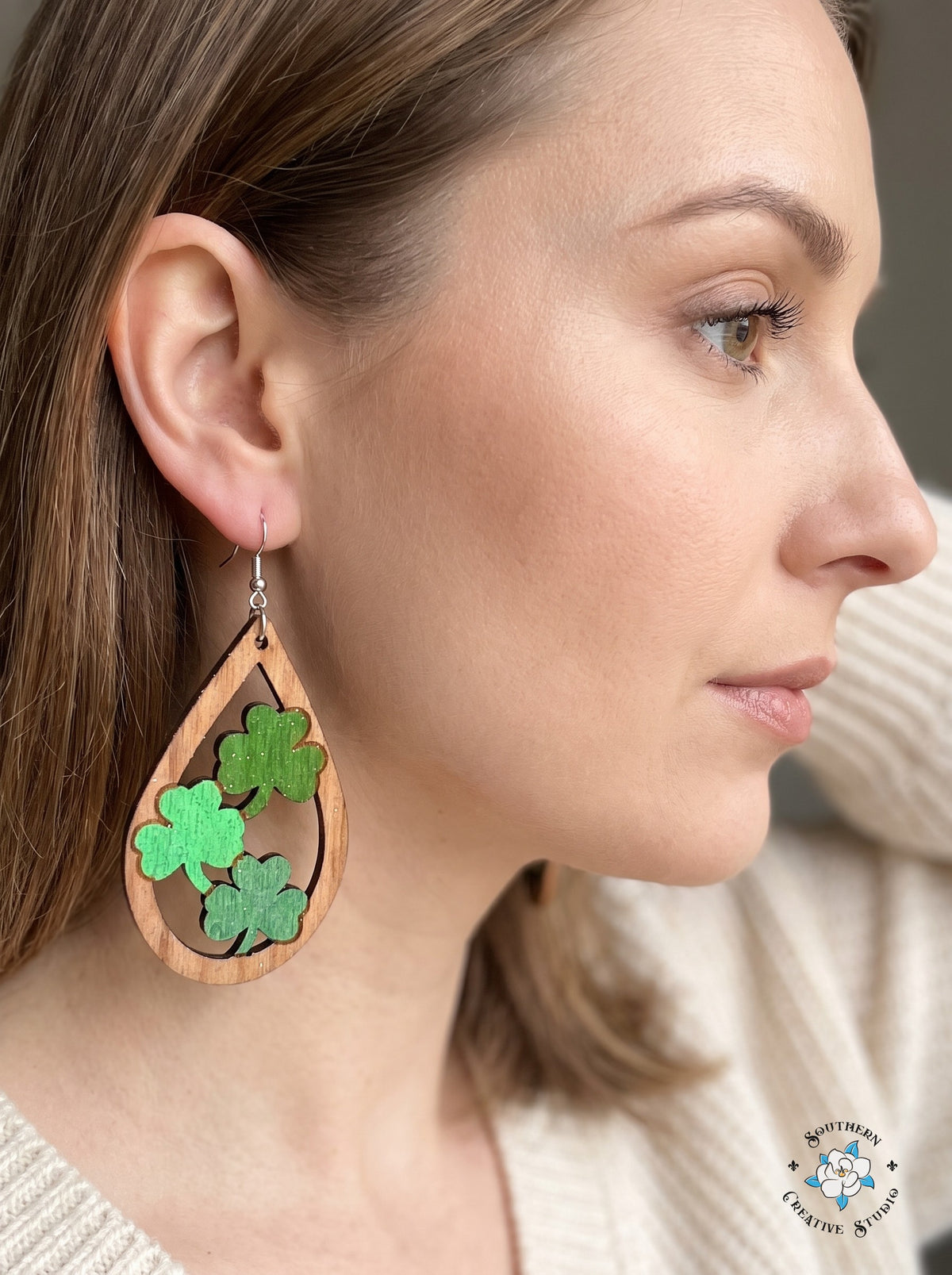 Woman wearing teardrop wood three clover dangle earrings