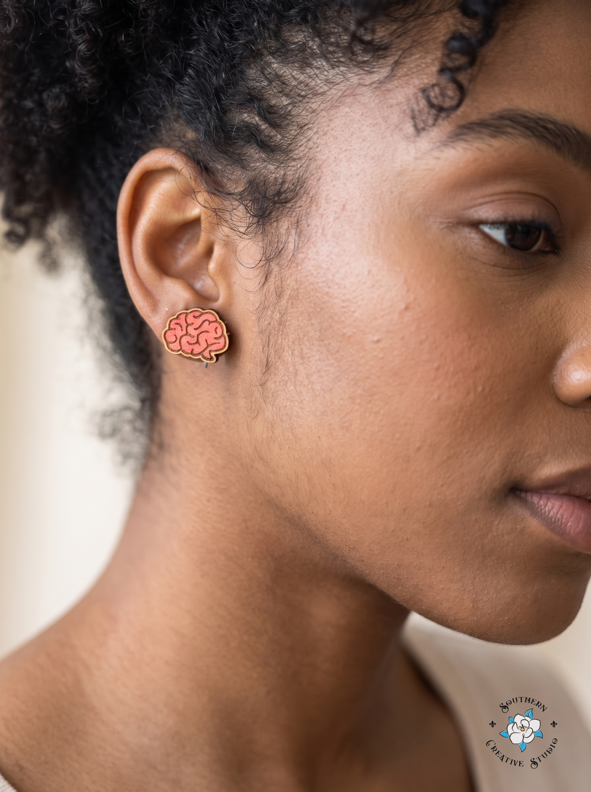 Close-up of pink brain wood stud earring worn in ear