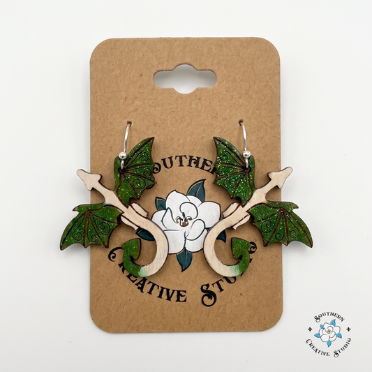 Hand-painted forest green dragon wood earrings on Southern Creative Studio kraft hang card
