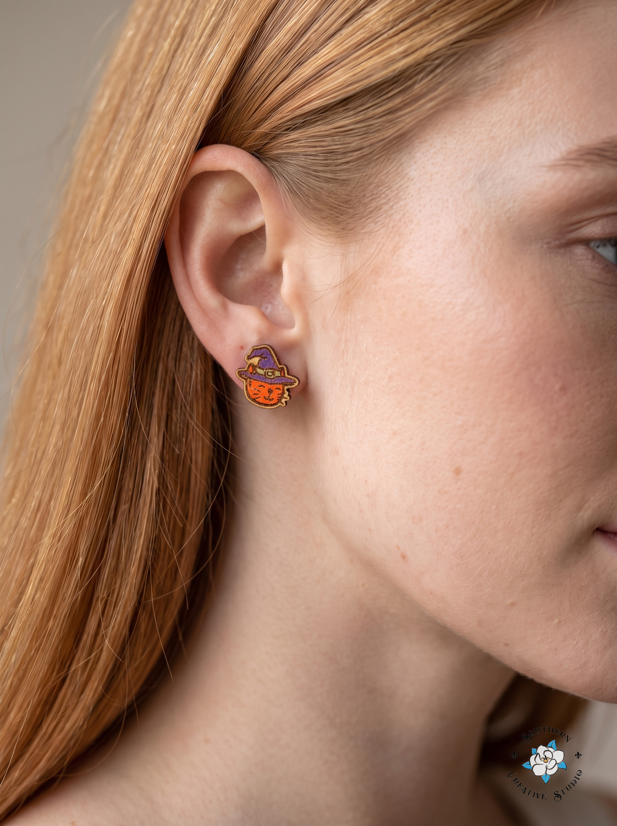 Woman wearing witch cat stud earring close-up