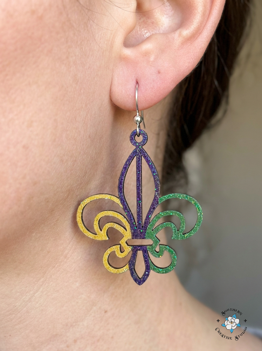 Close up of Mardi Gras Fleur-de-Lis hand-painted wood earring on ear