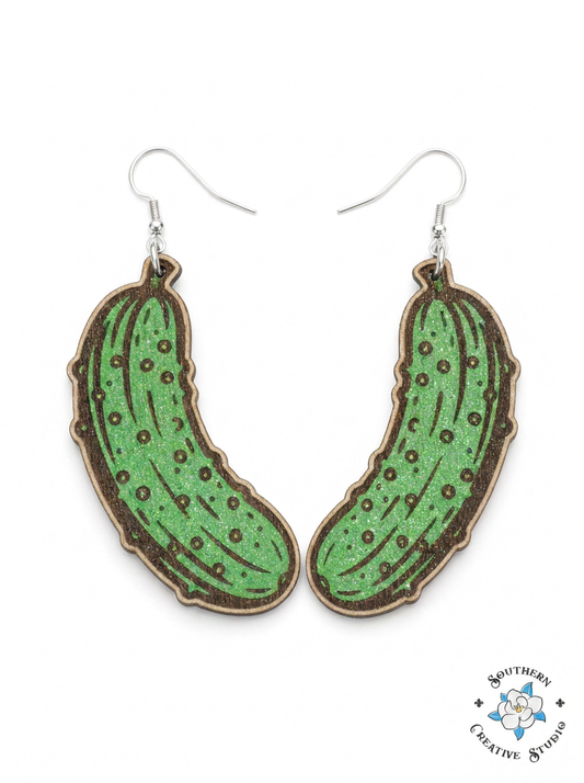 Hand-painted green glitter wood pickle dangle earrings on white background – Southern Creative Studio